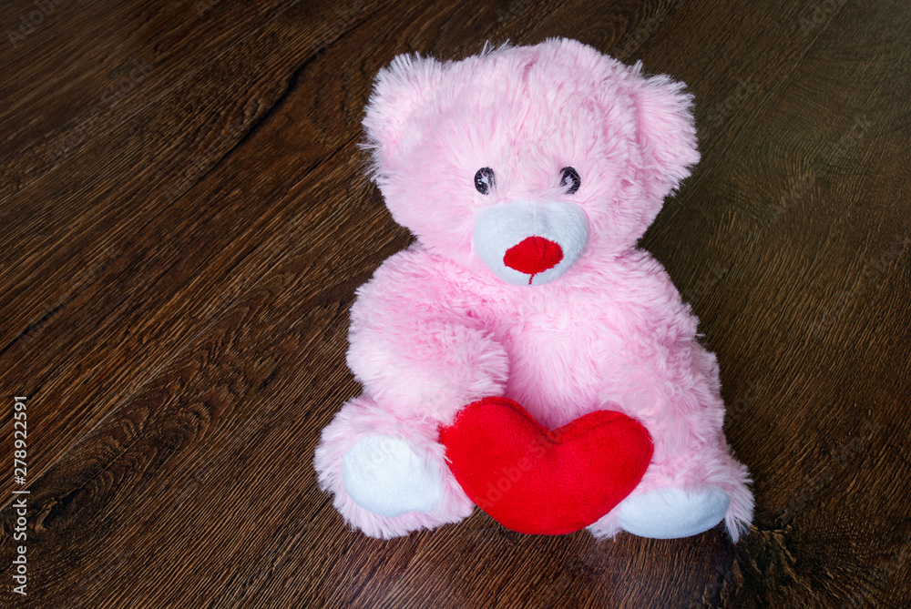 Obraz premium toy teddy with heart isolated on wooden background