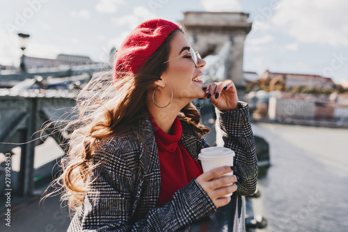 Photography Carefree caucasian woman in red hat enjoying city views in warm windy day