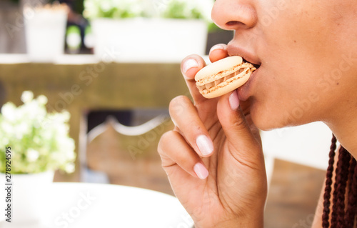 Girl eating macaron.