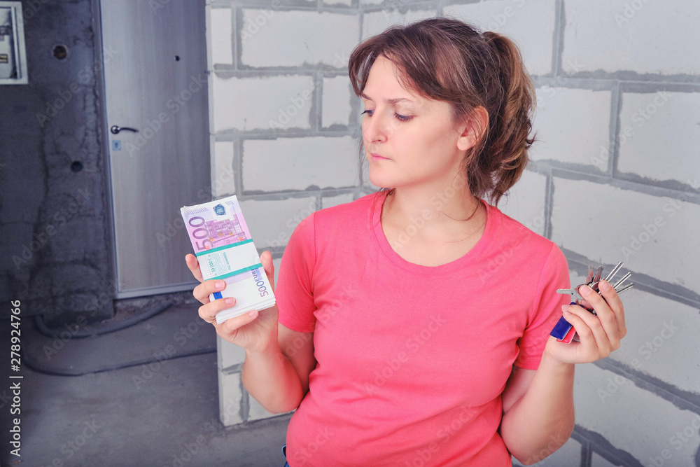 Young woman with Euro money in new apartment. The girl doubts the purchase of an apartment. Spending money on a new house without repairs. Young woman with Euro money in new apartment. The girl doubts the purchase of an apartment. Spending money on a new house without repairs.