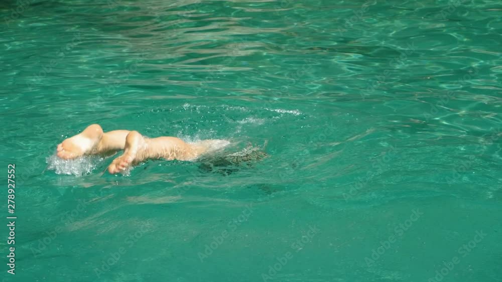 Beautiful woman in swimsuit diving into water, swimming in sea on summer vacation in Greece. Slow motion. HD