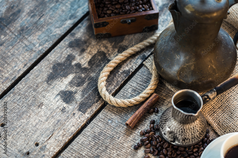 coffee cup, metal turk and coffee beans on a wooden background coffee cup, metal turk and coffee beans on a wooden background