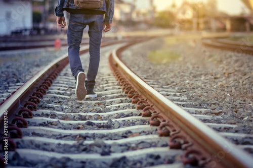 Man walk away on railroad with warm light.Selective focus.Traveler man on railroad.