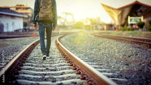 Man walk away on railroad with warm light.Selective focus.Traveler man on railroad.