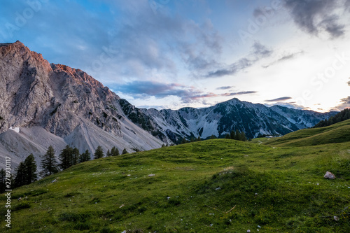 Fototapeta Naklejka Na Ścianę i Meble -  Idyllische Alm mit mächtigen Bergen im Hintergrund in den österreichischen Alpen