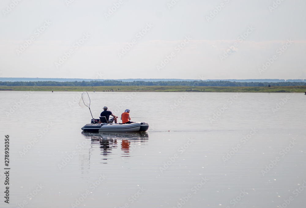 Fishermen on the river in a motor rubber boat