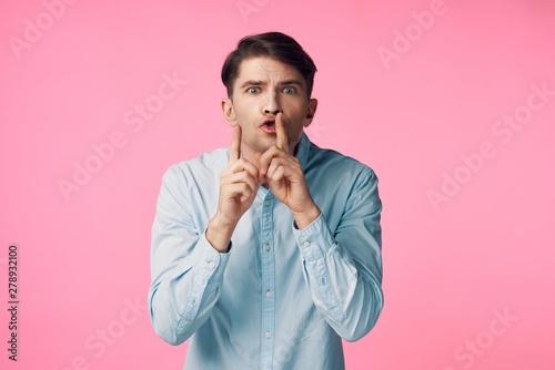 portrait of young man with his finger on lips