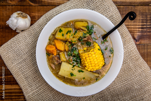 Sancocho - puerto rican beef stew on wooden table top view photo
