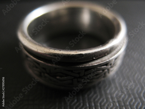 Man`s silver ring on futuristic surface. Vintage style. Close up photo. Focus on front view.