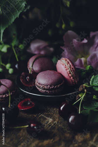 Macarons decorated with flowers on a dark rustic background