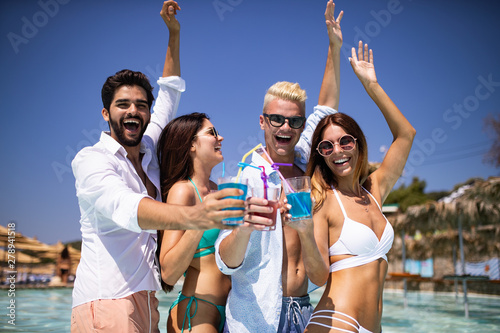 Group of friends having fun at summer party and drinking cocktail