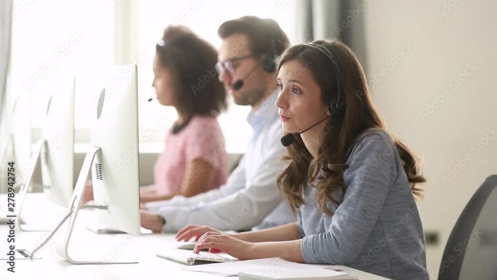 Young woman customer care agent in headset consulting online client