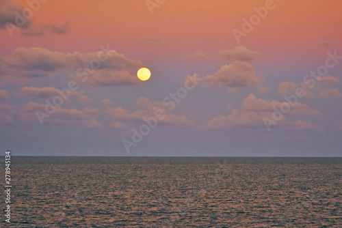 Full moon over sea at colourful sunset on a tropical island. 4k time-lapse