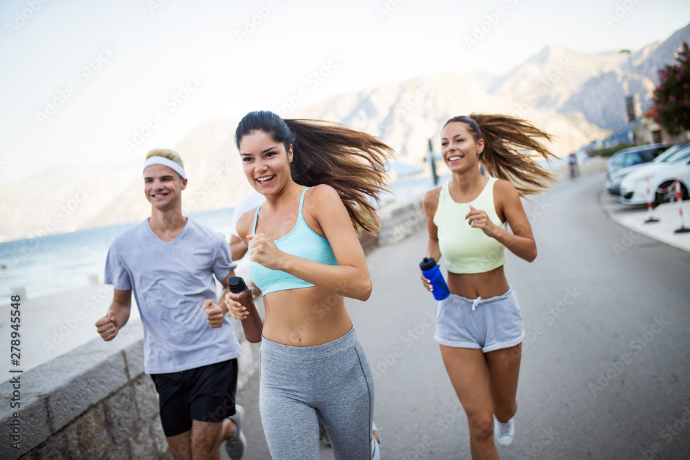 Happy fit people running and jogging together in summer sunny nature Happy fit people running and jogging together in summer sunny nature