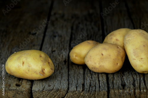 Fresh potatoes on an old wooden table
