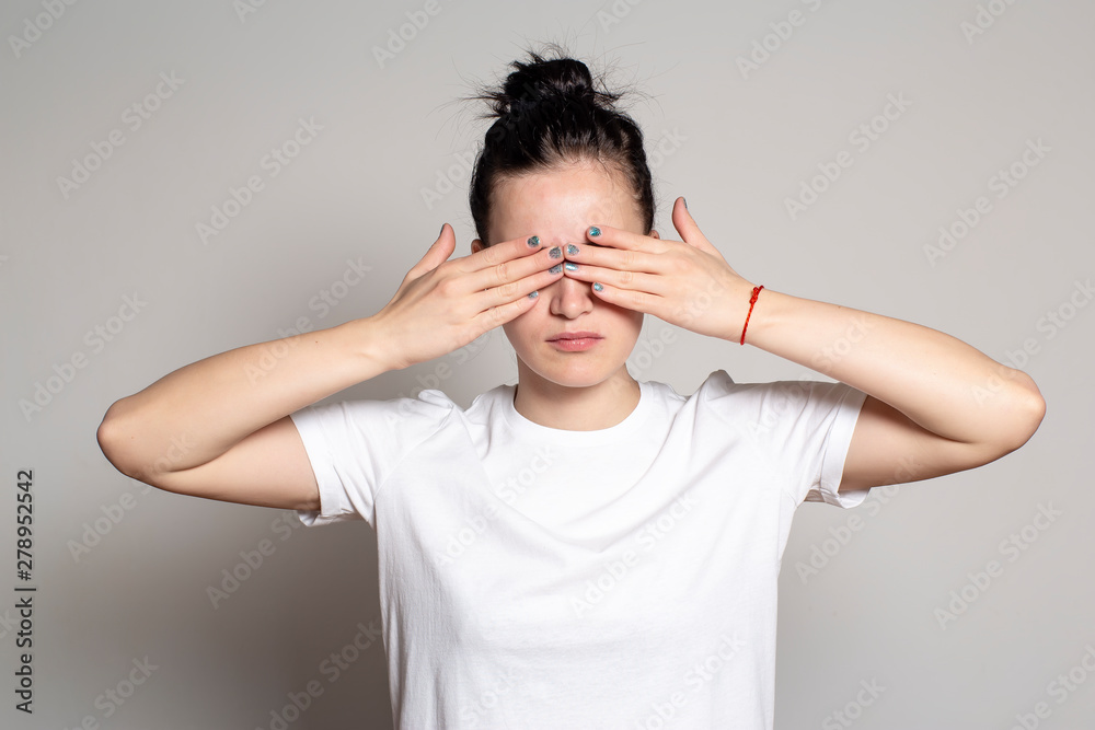 Pretty woman closes eyes with hands. Isolated on white background. Pretty woman closes eyes with hands. Isolated on white background.