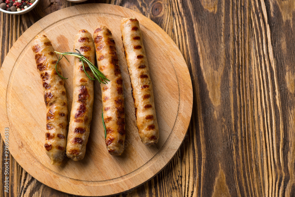 Grilled sausages with sauce ketchup on a wooden table Grilled sausages with sauce ketchup on a wooden table