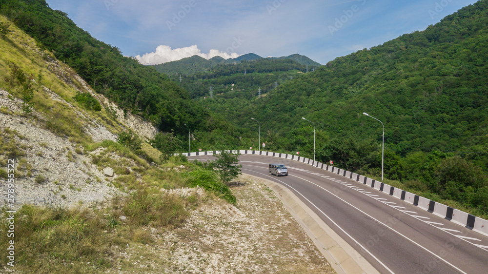 Birds Eye View - winding road from the high mountain pass in Sochi, Russia. Great road trip trough the dense woods.