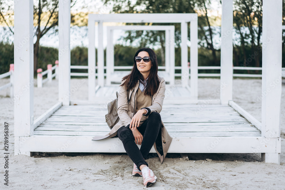 Pretty long hair brunette girl in sunglasses relaxing outdoor.