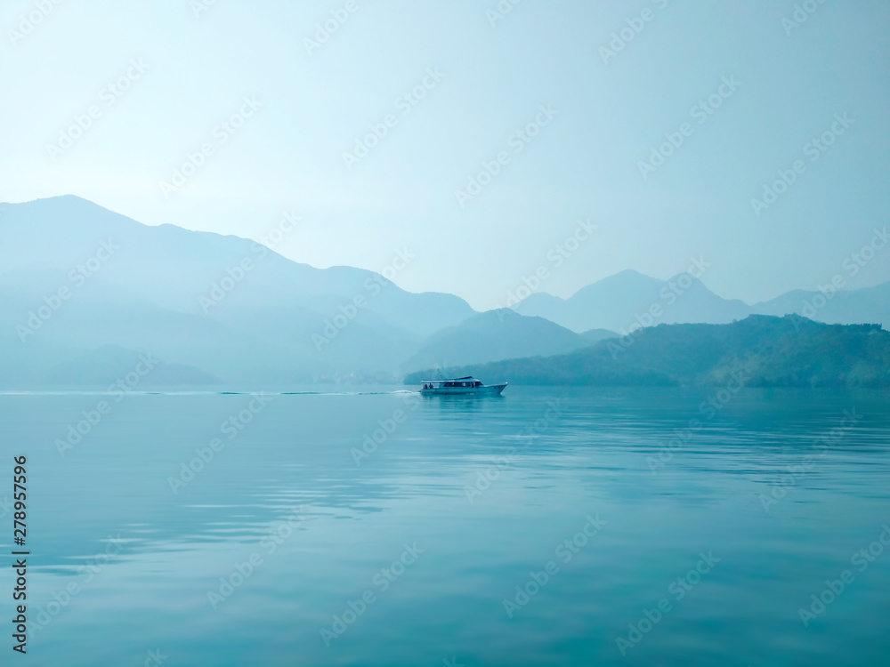 Large blue lake with lonely ship in the morning
