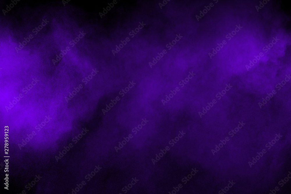 Freeze motion explosion of purple powder dust on a black background. By throwing blue talcum  out of hand. Stopping the movement of purple powder on dark background.