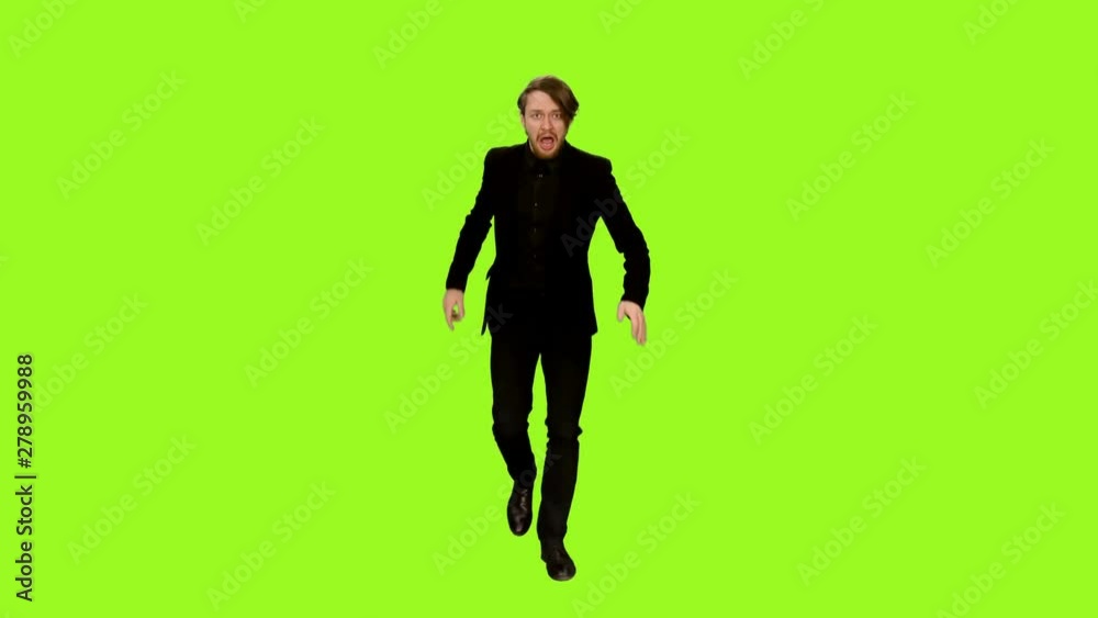 Business man runnung away scared terrify and looking over his shoulder and screaming on green screen background