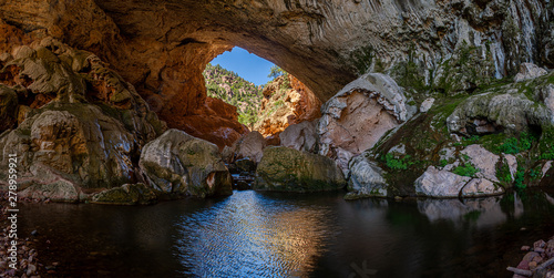 Inside Tonto Natural Bridge in the mountains of Arizona looking at the pond inside of the bridge. photo