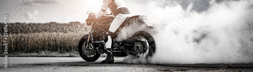 dziki motocyklista pozwala oponom kręcić się po wypaleniu i robi pączka