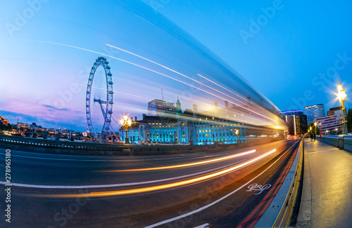 London Eye view from the bridge of Westminster over the big wheel and car traces on the road, in UK photo