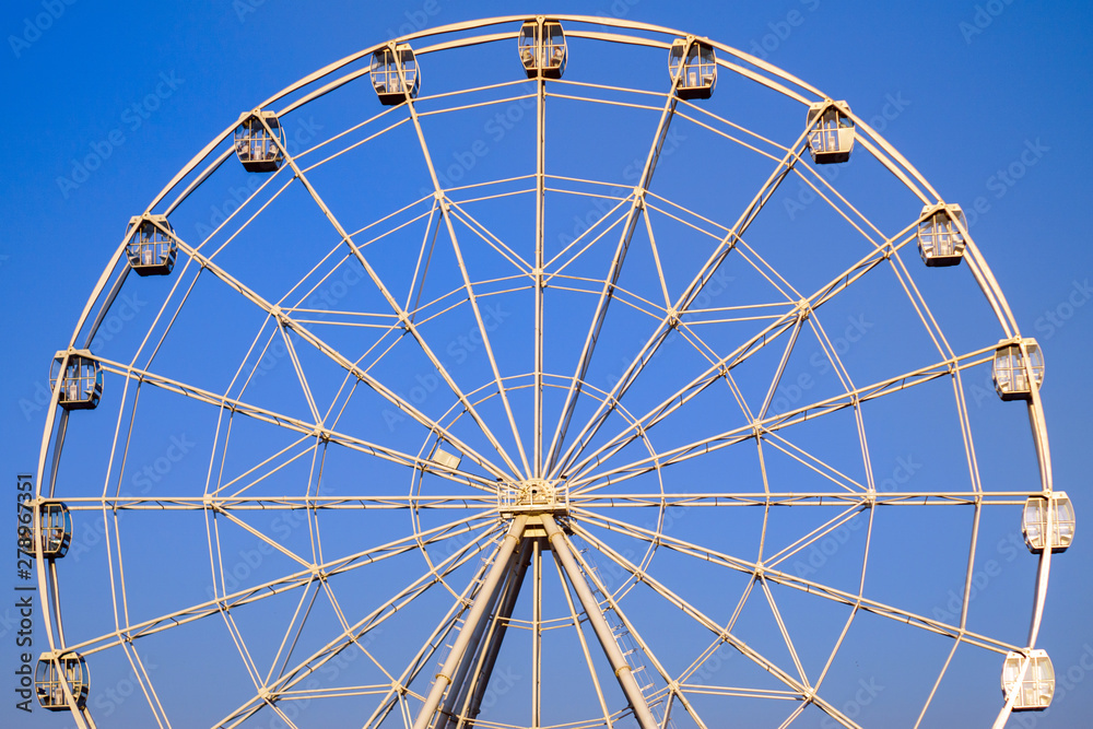 Ferris wheel in summer in the blue sky