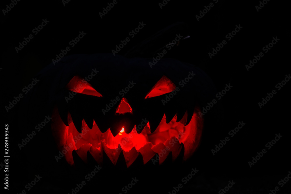 Naklejka premium scary pumpkin for Halloween on a black background