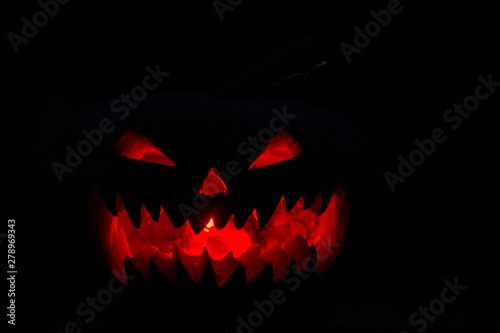 scary pumpkin for Halloween on a black background