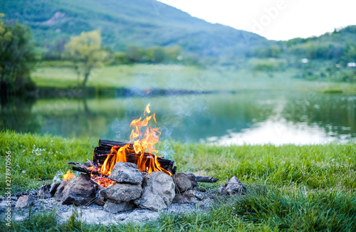 Burning coal in the bonfire. Burning fire in nature on the background of the lake The embers in the fire.