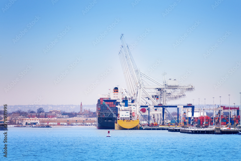 Marine cranes loading containers on cargo ship