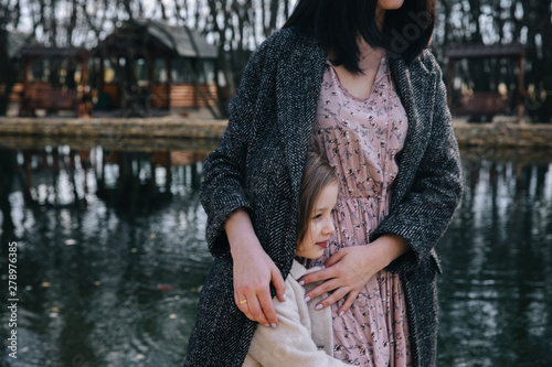 Mom and his daughter are playing and hugging outdoor photo