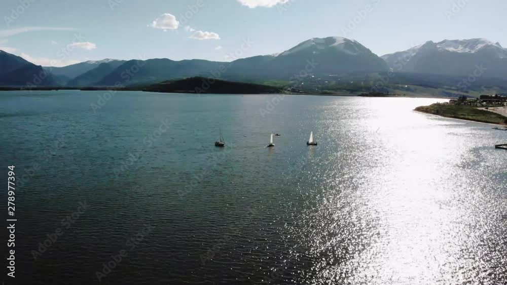 Sailing boats enjoy warm day in Colorado, aerial pan with mountains in background 4k Sailing boats enjoy warm day in Colorado, aerial pan with mountains in background 4k