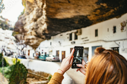 Female tourist photographing the overhanging cliff