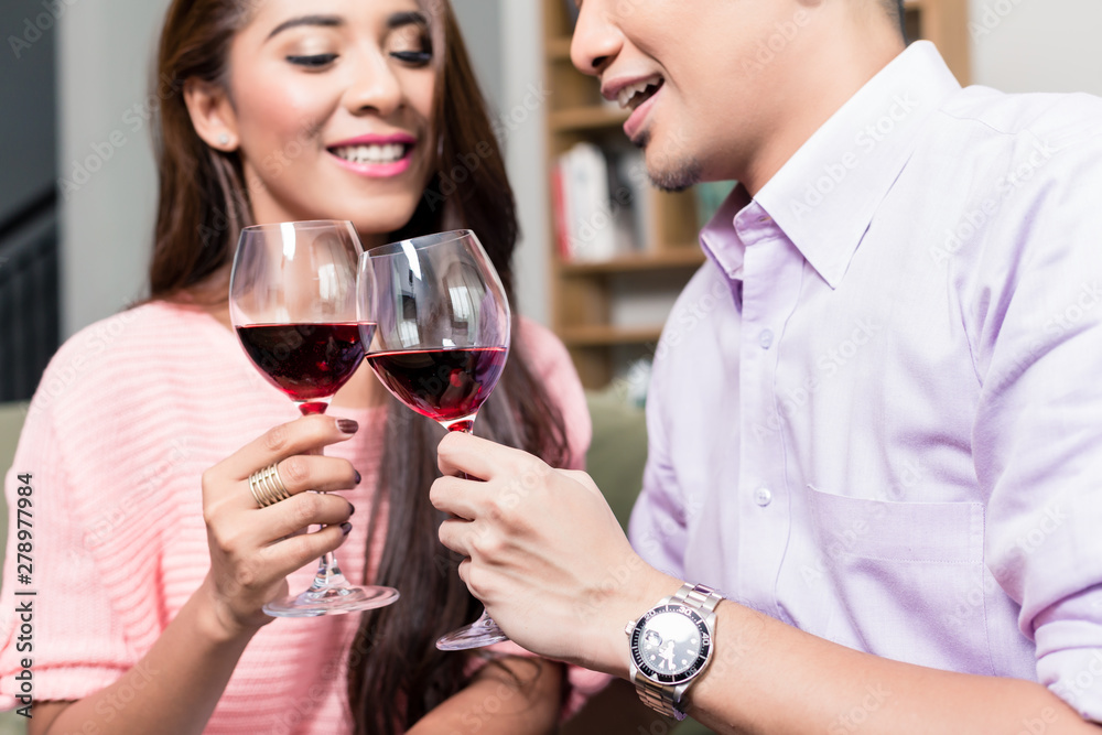 Smiling couple toasting red wineglasses Smiling couple toasting red wineglasses