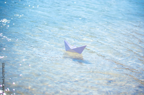 paper boat on the waves of blue water