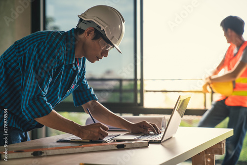 Architect & Engineer working drawing document about project planning and progress of work schedule on the home building construction site