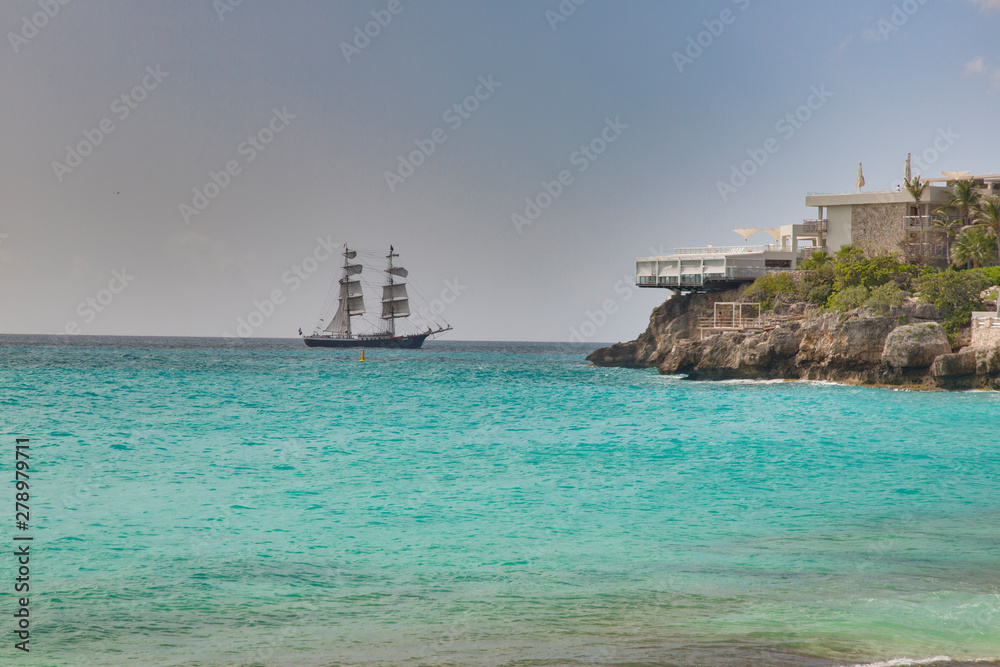 Sailing ship in turquoise waters on carrebbian island of St. Maarten