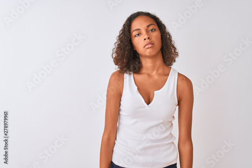 Young brazilian woman wearing casual t-shirt standing over isolated white background looking sleepy and tired, exhausted for fatigue and hangover, lazy eyes in the morning.