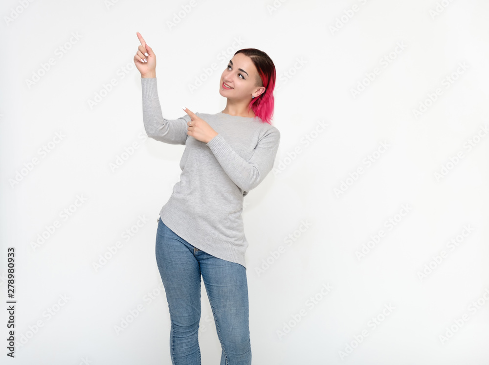 Portrait of a knee-high pretty girl with red hair on a white background in a gray sweater and blue jeans. Standing right in front of the camera with emotions, talking, showing hands, smiling Portrait of a knee-high pretty girl with red hair on a white background in a gray sweater and blue jeans. Standing right in front of the camera with emotions, talking, showing hands, smiling