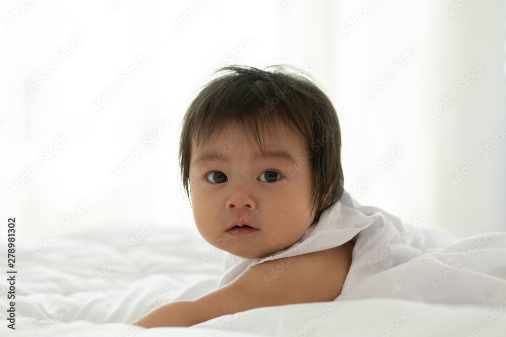 Cute Sweet Adorable Asian Baby wearing white dress lying on white bed smiling and playing with happiness emotional in cozy bedroom,Healthy Baby Concept Cute Sweet Adorable Asian Baby wearing white dress lying on white bed smiling and playing with happiness emotional in cozy bedroom,Healthy Baby Concept
