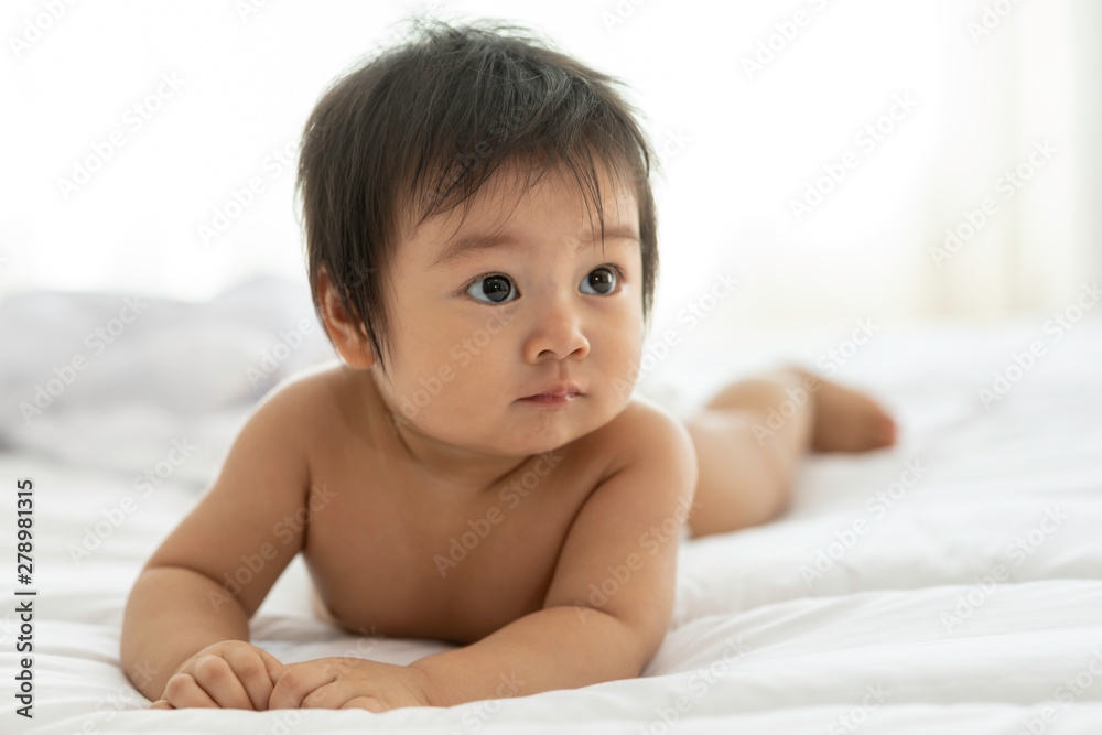 Cute Sweet Adorable Asian Baby wearing white dress lying on white bed smiling and playing with happiness emotional in cozy bedroom,Healthy Baby Concept Cute Sweet Adorable Asian Baby wearing white dress lying on white bed smiling and playing with happiness emotional in cozy bedroom,Healthy Baby Concept