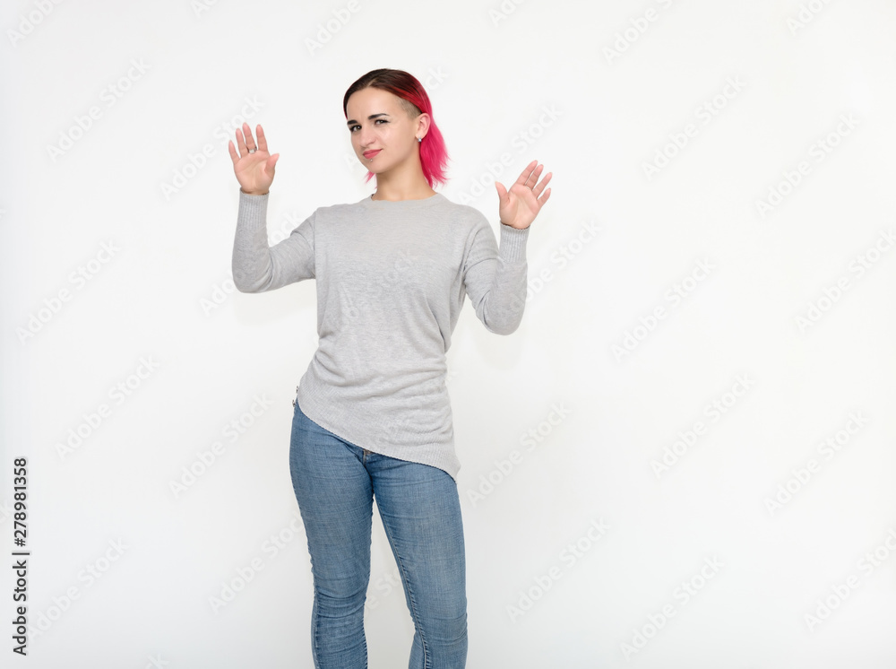Portrait of a knee-high pretty girl with red hair on a white background in a gray sweater and blue jeans. Standing right in front of the camera with emotions, talking, showing hands, smiling Portrait of a knee-high pretty girl with red hair on a white background in a gray sweater and blue jeans. Standing right in front of the camera with emotions, talking, showing hands, smiling