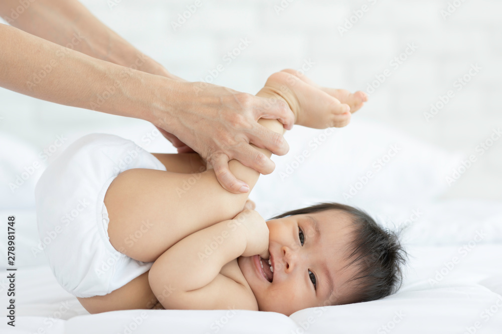 Close up mother Hands Holding Baby leg and Exercise for Healthy on bed smiling and happiness emotional in cozy bedroom,Healthy Baby Concept Close up mother Hands Holding Baby leg and Exercise for Healthy on bed smiling and happiness emotional in cozy bedroom,Healthy Baby Concept