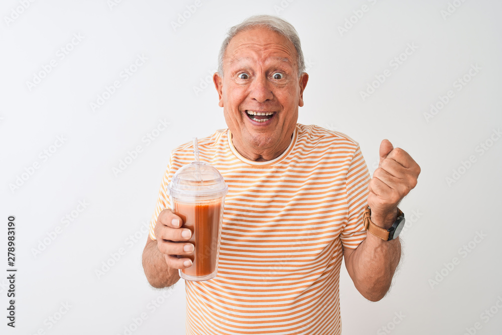 Senior man wearing striped t-shirt drinking tomato smoothie over isolated white background screaming proud and celebrating victory and success very excited, cheering emotion Senior man wearing striped t-shirt drinking tomato smoothie over isolated white background screaming proud and celebrating victory and success very excited, cheering emotion