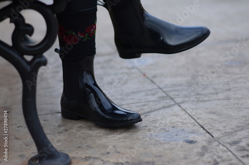 Autumn Boots. Woman with waterproof shiny black boots. Selective focus.