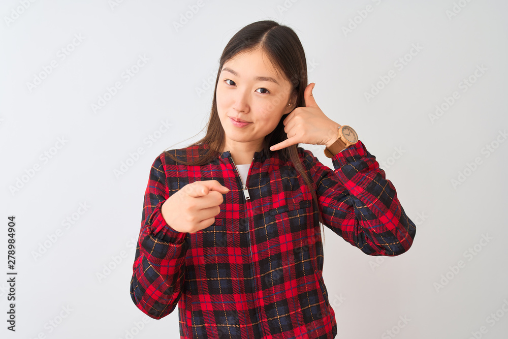 Young chinese woman wearing casual jacket standing over isolated white background smiling doing talking on the telephone gesture and pointing to you. Call me. Young chinese woman wearing casual jacket standing over isolated white background smiling doing talking on the telephone gesture and pointing to you. Call me.
